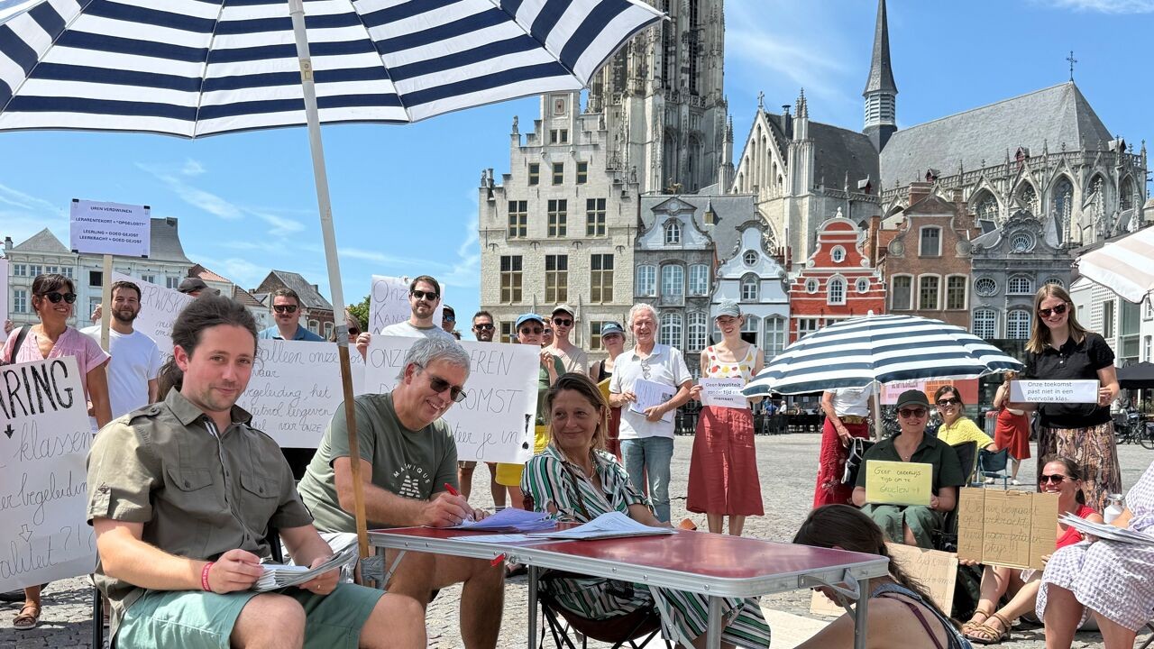 Leerkrachten verbeteren examens op Grote Markt in Mechelen tijdens protest tegen lesuren die ze verliezen door besparingen